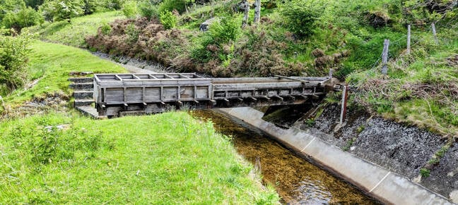 This wooden gutter carries water from a mountain stream over one on the leats