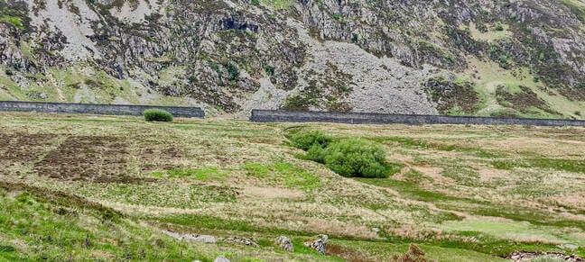 The breach in Eigiau from the far side of Cwm Eigiau. The dam is little more than a long concrete wall. The floodwater carved a channel into the valley floor before joining the Afon Porth-Llwyd in the foreground.